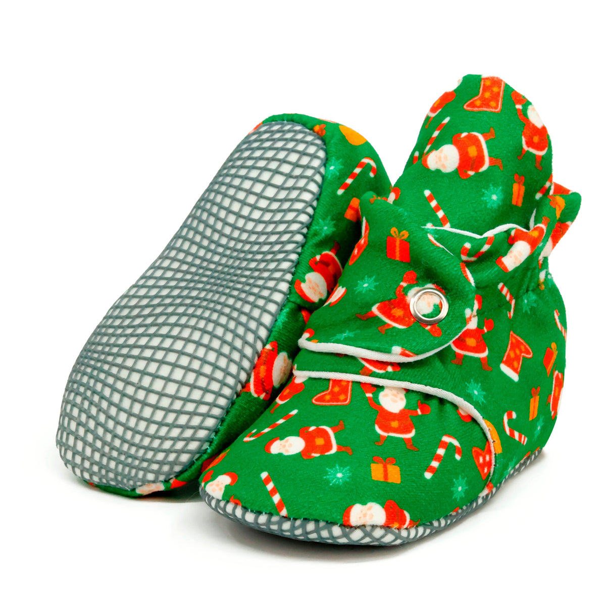 Green baby booties with Santa Claus Christmas print and snap straps, with one sole facing the camera on a white background.