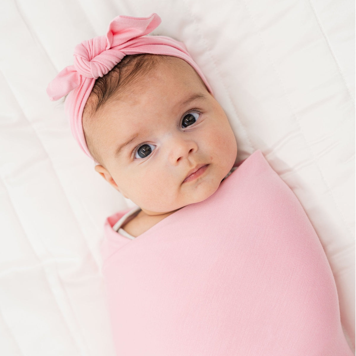 Close-up of a baby wrapped in Bam & Stitch Pink Blossom Swaddle.