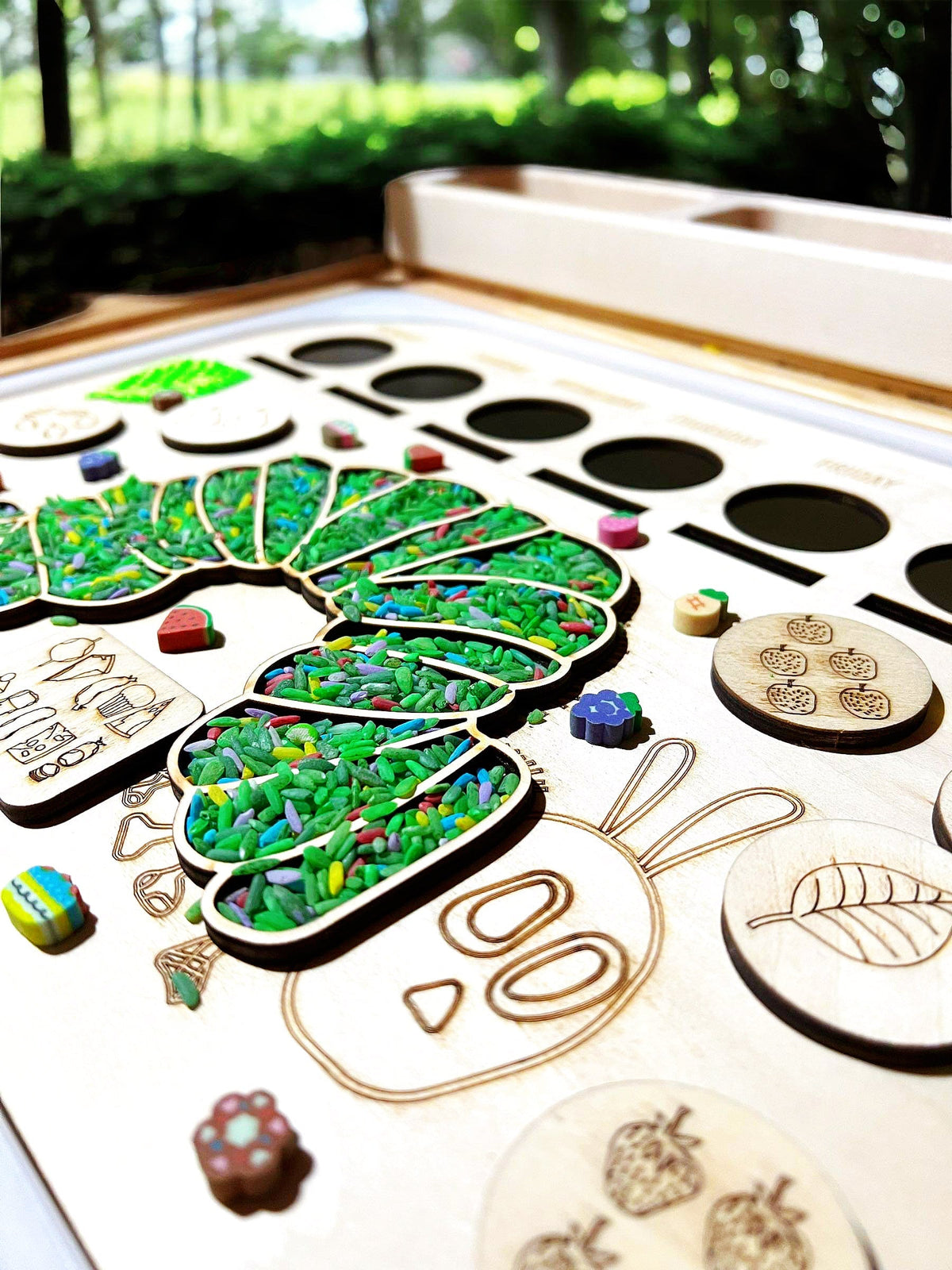 Dinosaur sensory bin activity board with wooden loose parts