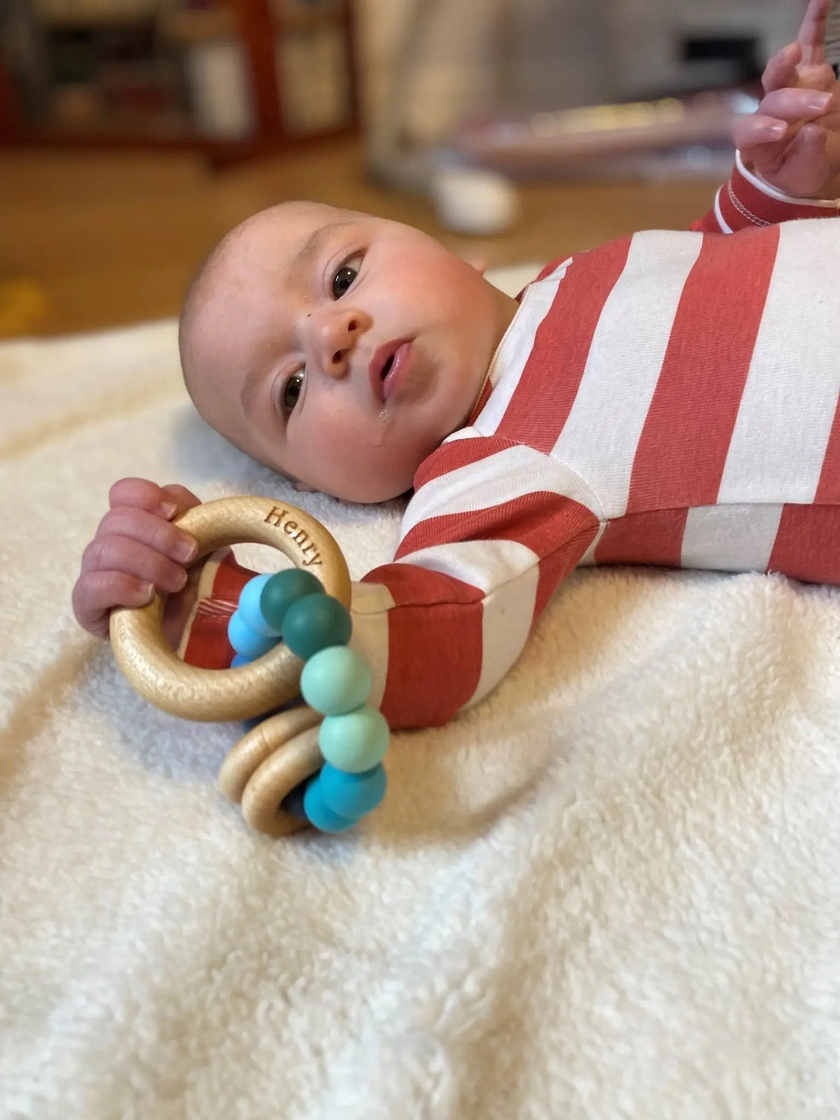 Lifestyle photo showing a wood and silicone teether with a child