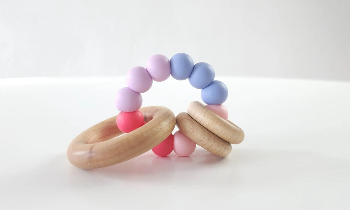 Saturn Ring Teether with pink and purple silicone beads and wooden rings