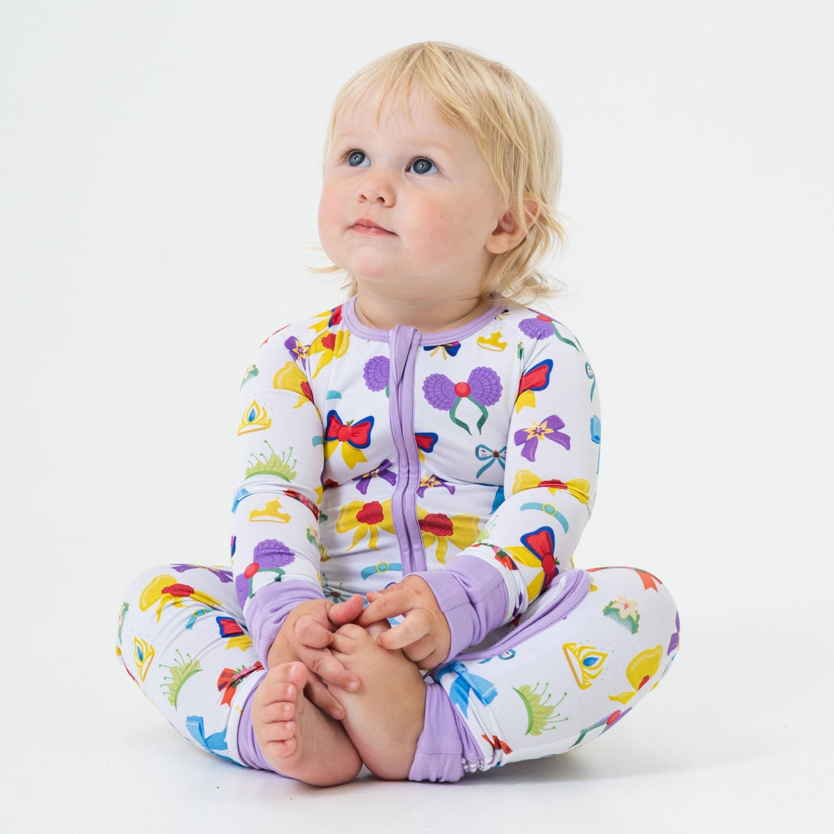 Baby sitting in Bam & Stitch Sparkle & Reign Convertible Romper.