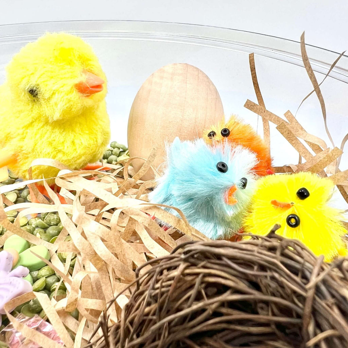 Yellow wind-up chick, colorful small chicks and an unpainted egg in the Spring Garden scene