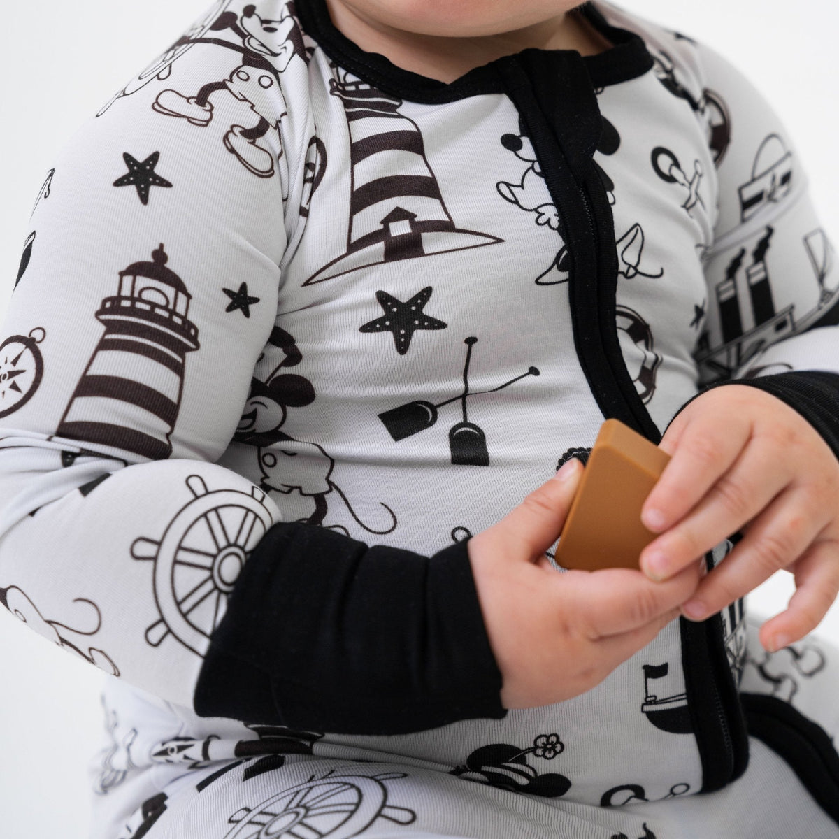 Close-up of the front zipper and fabric on Bam & Stitch Steamboat Willie Convertible Romper.