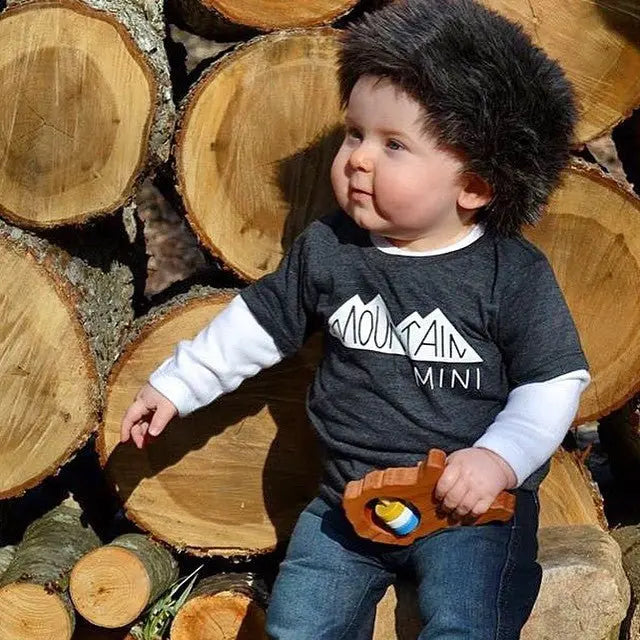 Lifestyle photo showing a wooden state rattle with a child