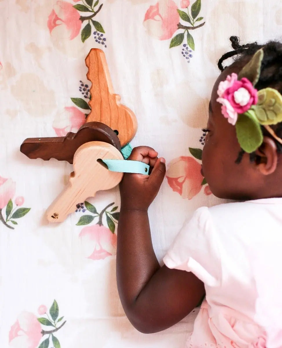 Lifestyle photo showing wooden toy keys with a child