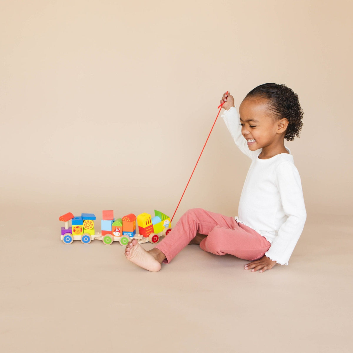 SpiritnSprout: Child seated with the train and holding its pull string
