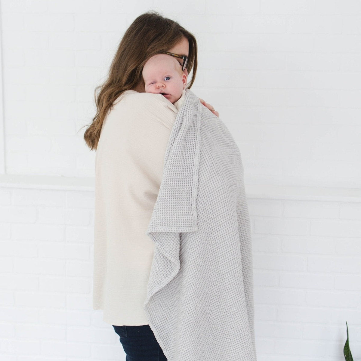 SpiritnSprout: Caregiver holding a baby with the grey blanket