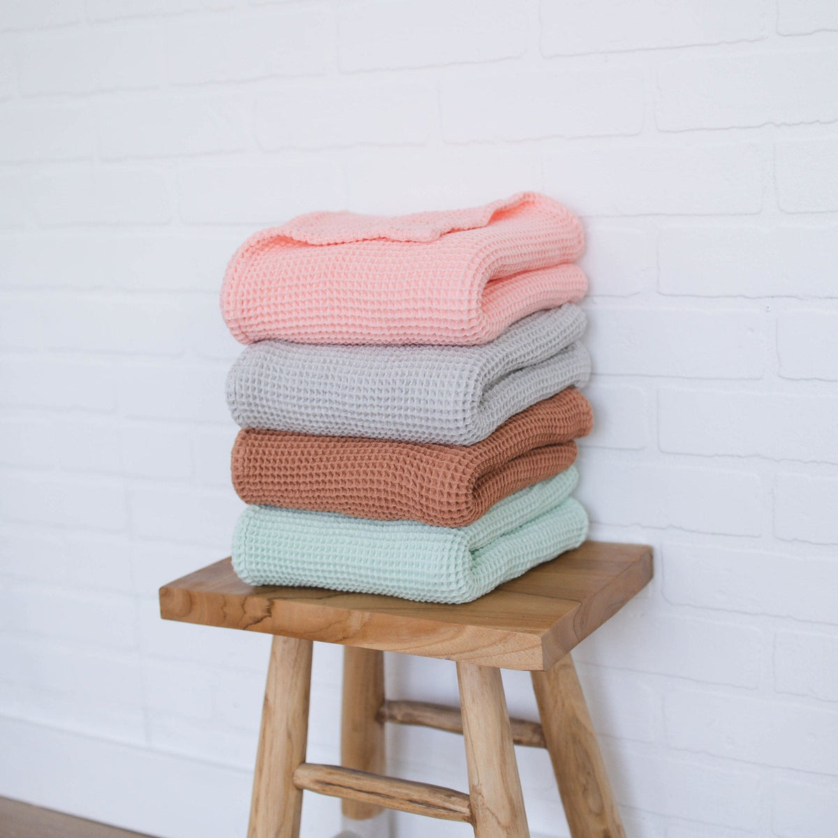 SpiritnSprout: Four blanket colors stacked on a wooden stool