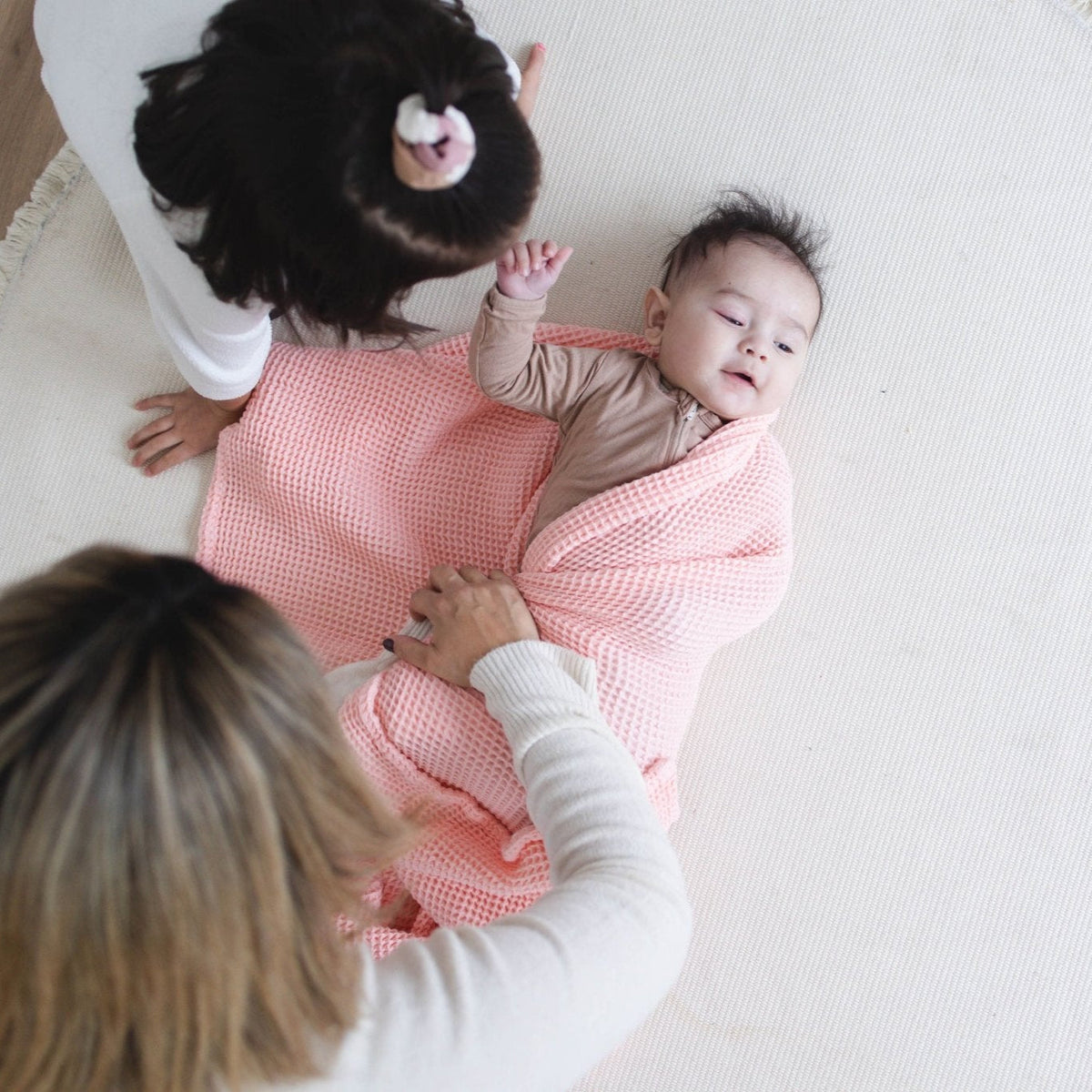 SpiritnSprout: Caregiver holding a baby wrapped in the rose pink blanket