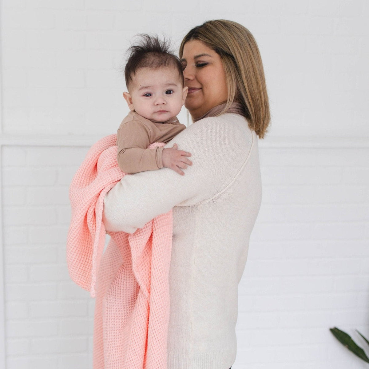 SpiritnSprout: Caregiver holding a baby with the rose pink blanket