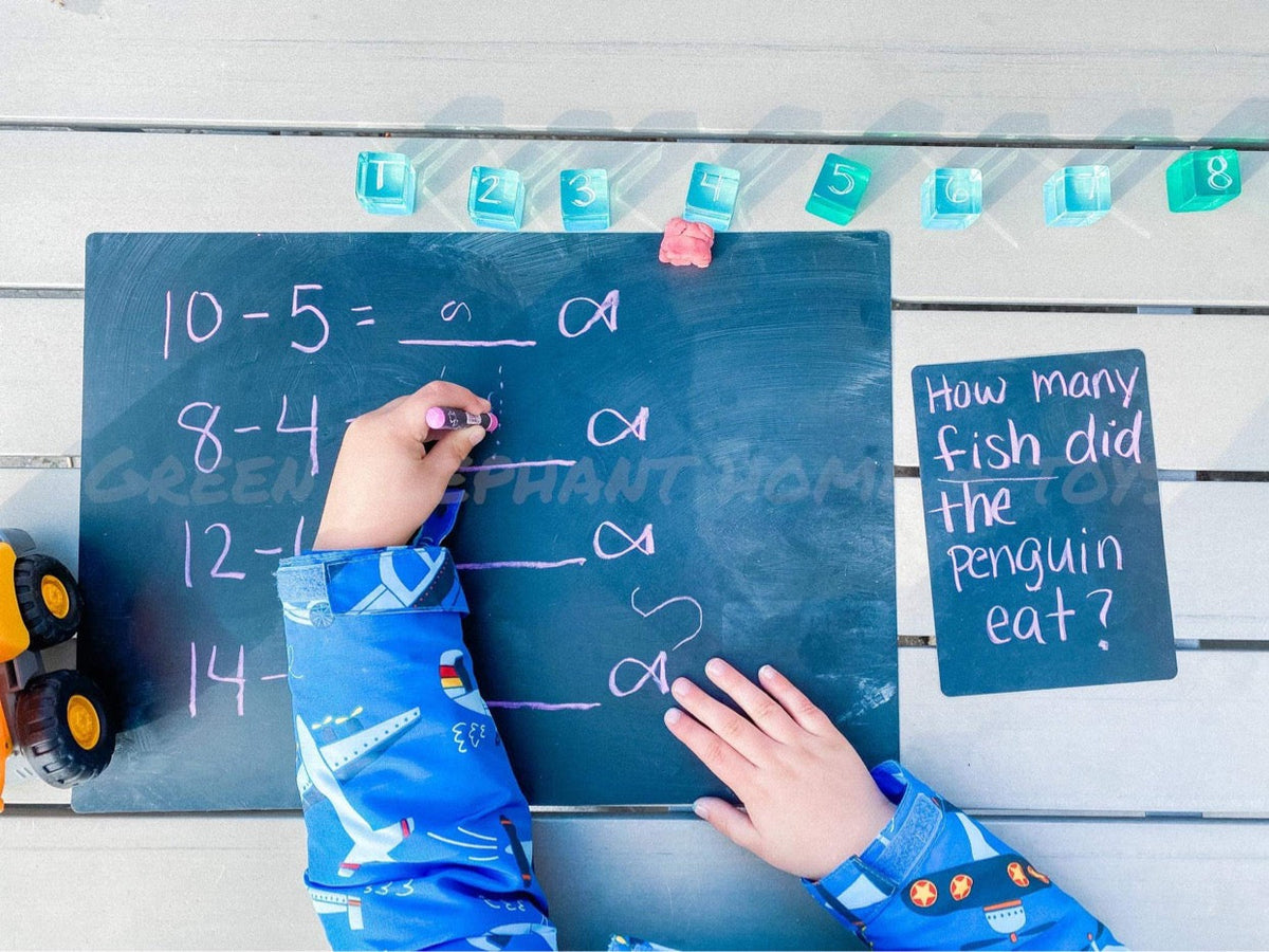 Child using lucite cubes for a counting activity beside a chalkboard
