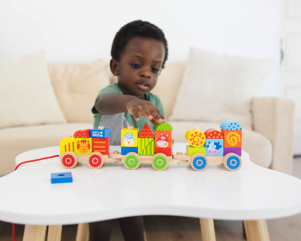 SpiritnSprout: Child seated at a round table behind the completed train