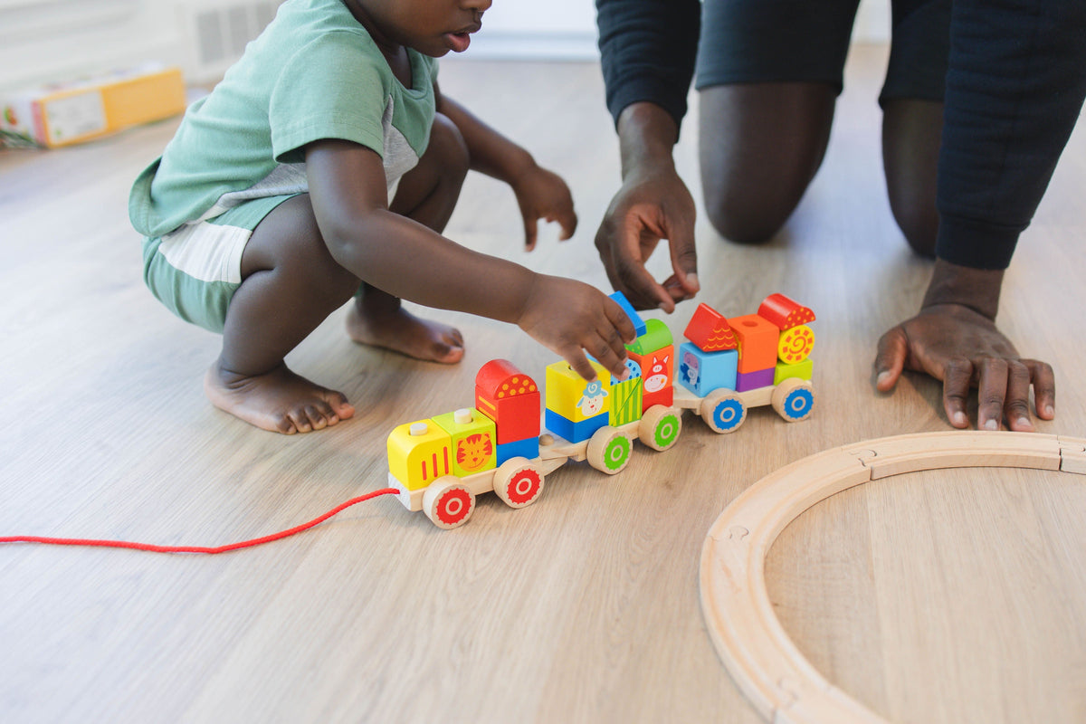 SpiritnSprout: Child and adult rearranging blocks on the train cars