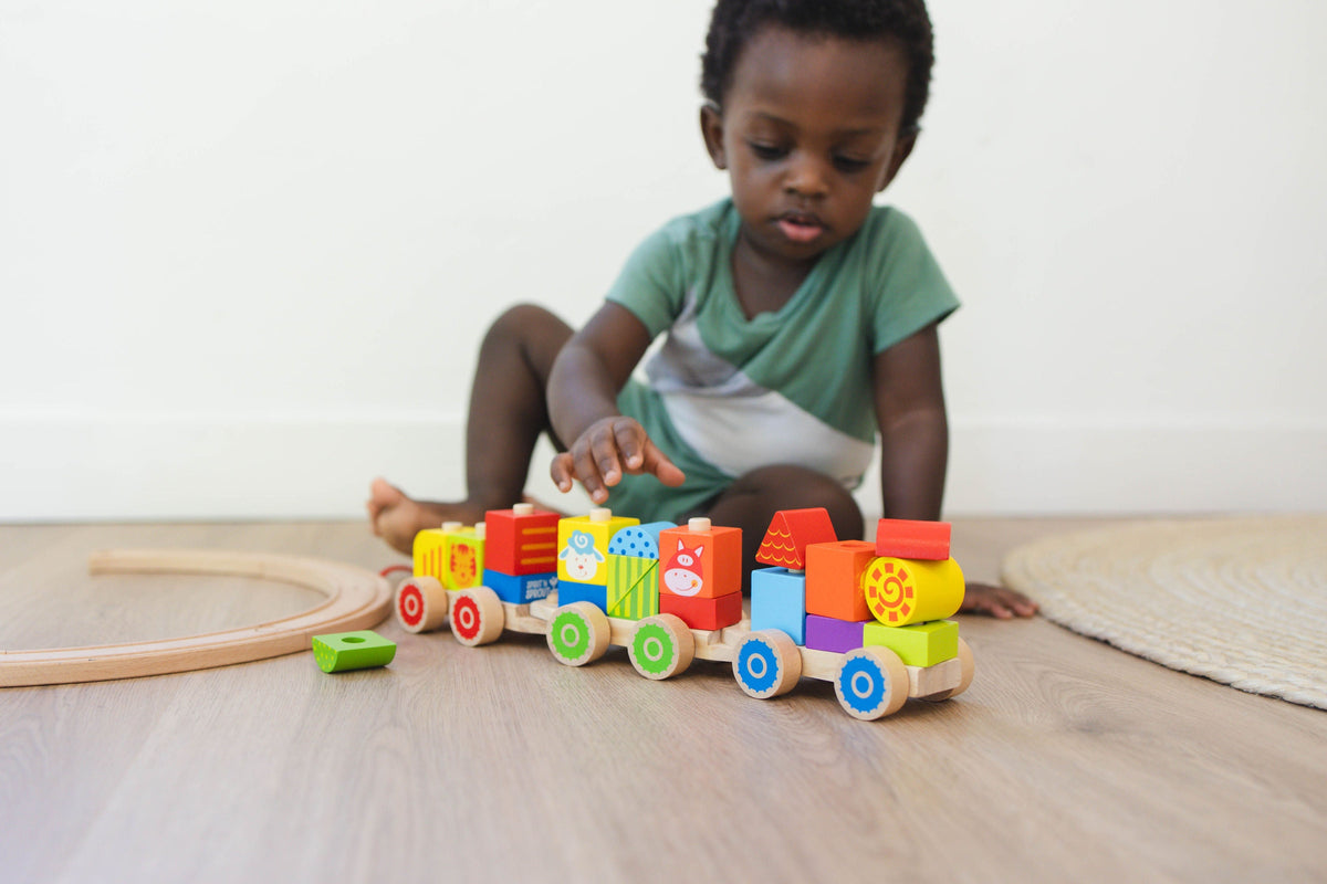 SpiritnSprout: Child playing with the assembled train on the floor
