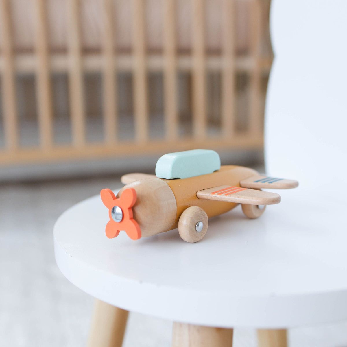 SpiritnSprout: Gold wooden airplane on a small white table