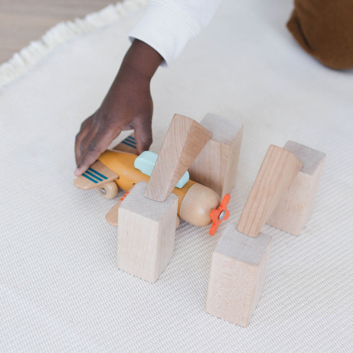 SpiritnSprout: Gold wooden airplane positioned among wooden building blocks