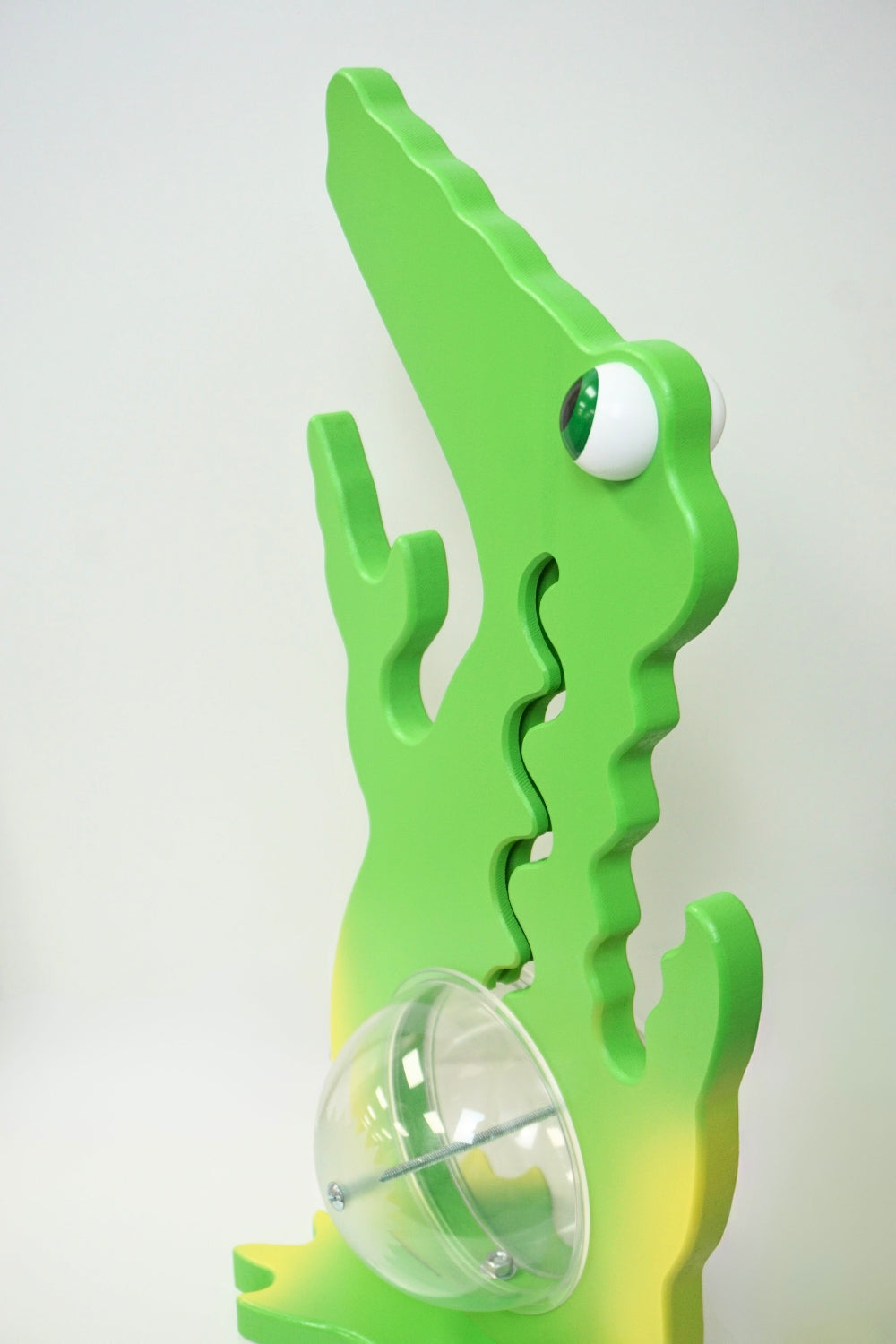Angled side view of the green and yellow alligator coin bank