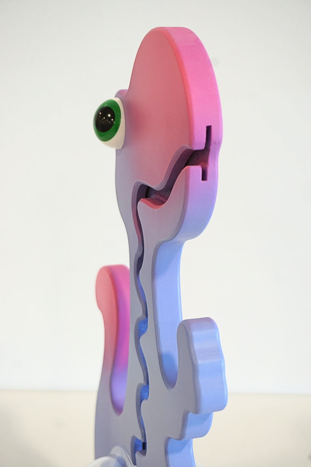 Side view of the purple and pink dinosaur head and coin-track opening
