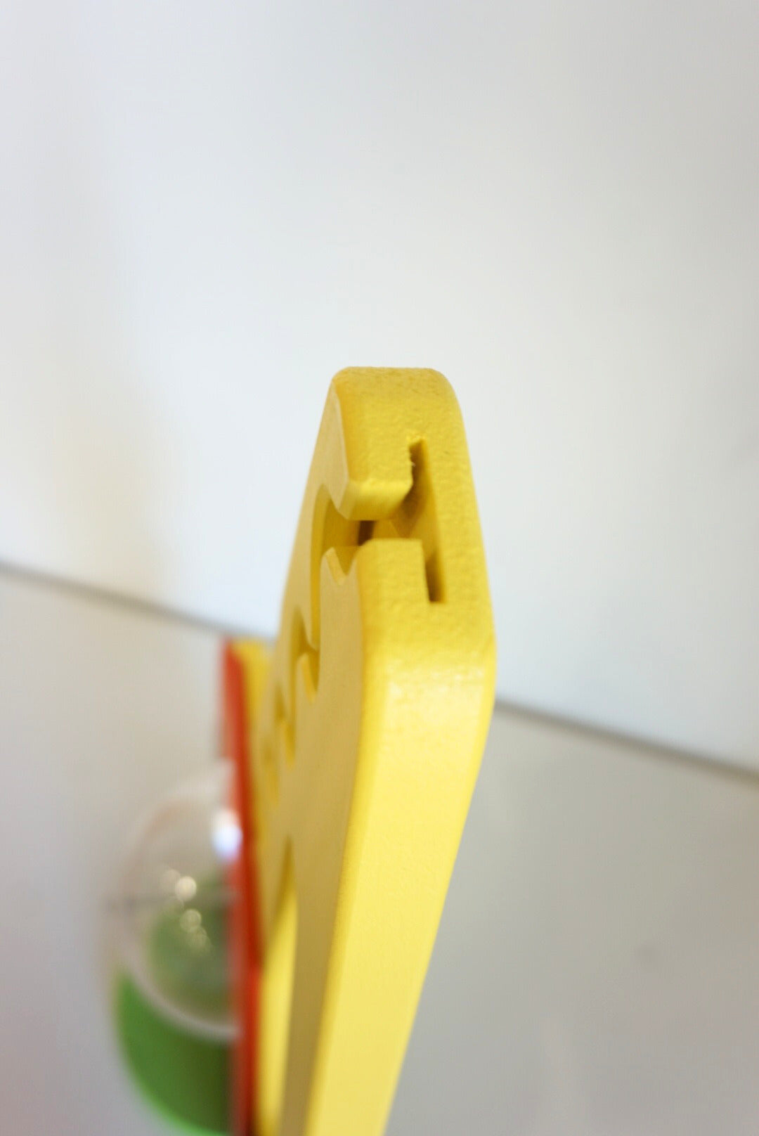 Edge-on close-up of the excavator coin-entry opening at the top of the raised arm