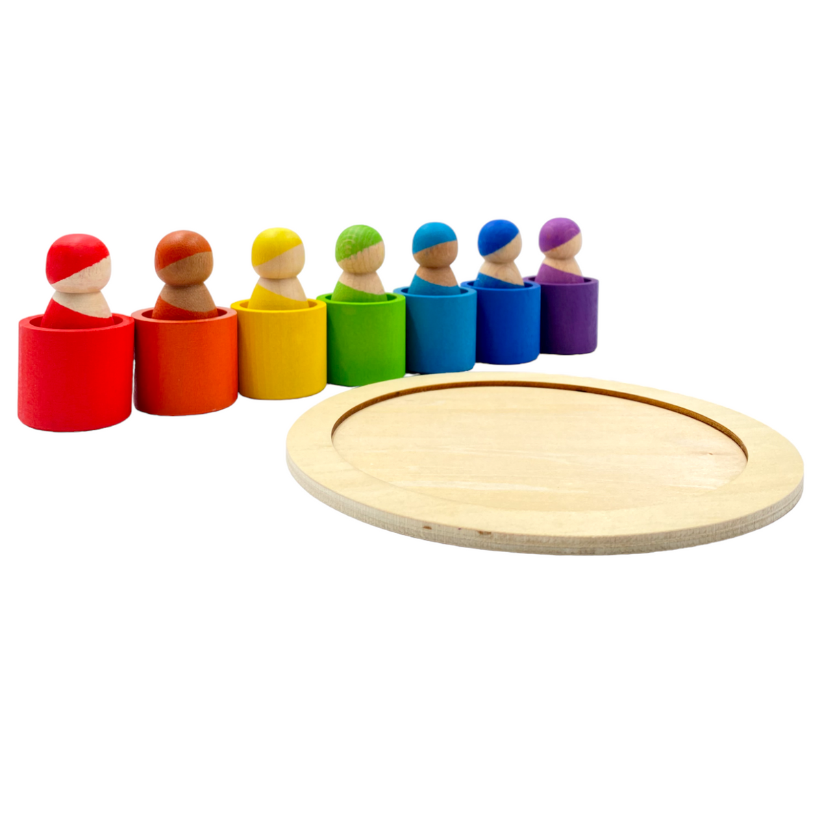 Seven dolls seated in rainbow bowls beside the empty round wooden tray