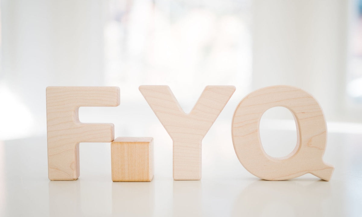 Wooden F, Y and Q alphabet grasping toys displayed upright