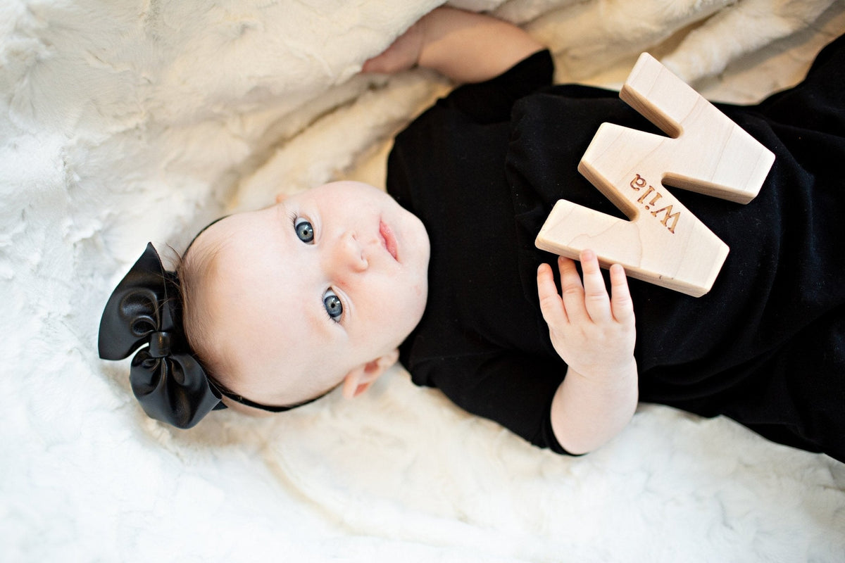 Lifestyle photo showing a wooden grasping toy with a child