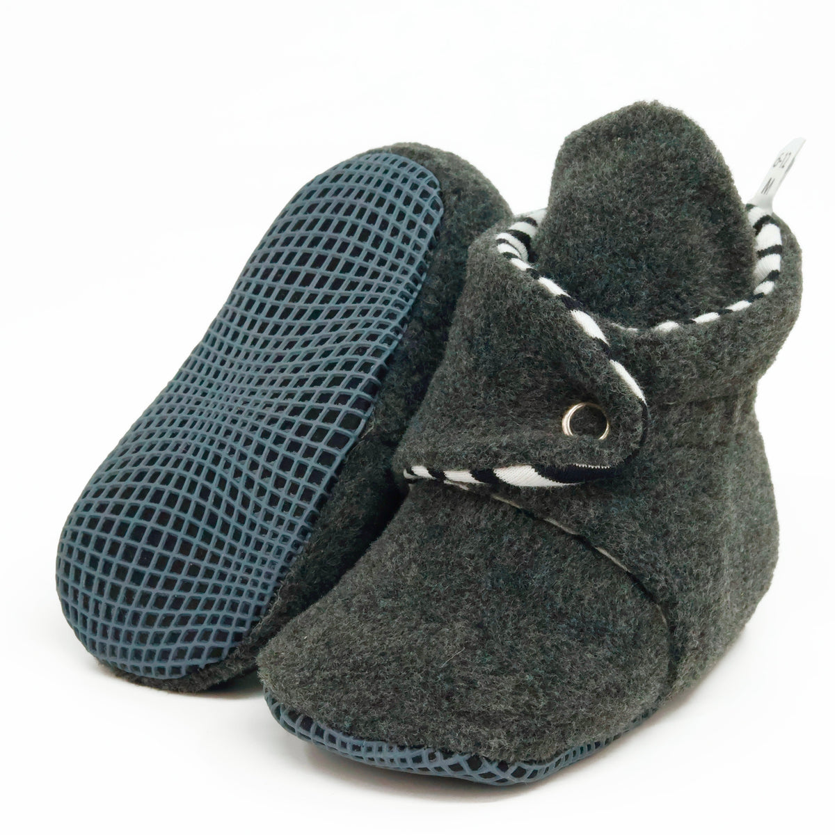 Charcoal fleece baby booties with striped lining and snap straps, with one sole facing the camera on a white background.