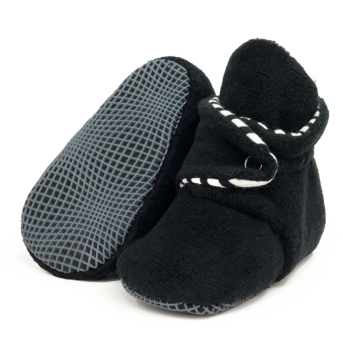 Black fleece baby booties with striped lining and snap straps, with one sole facing the camera on a white background.