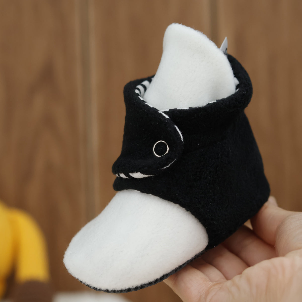 Single bootie held in a hand, side view.