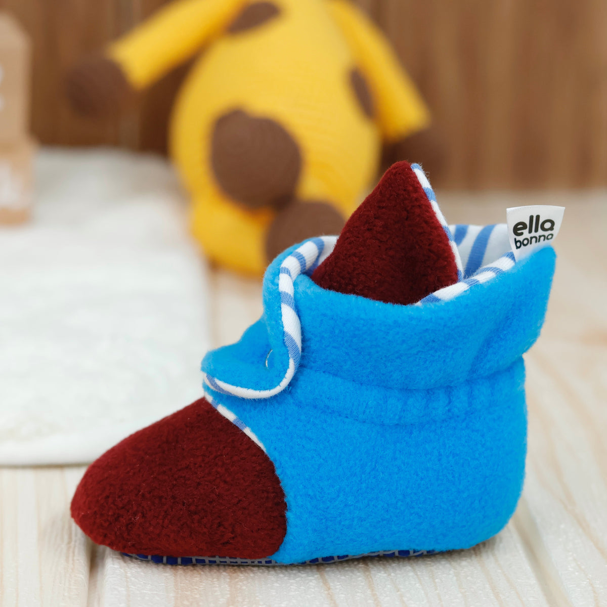 Single bootie on a tabletop, close side view.