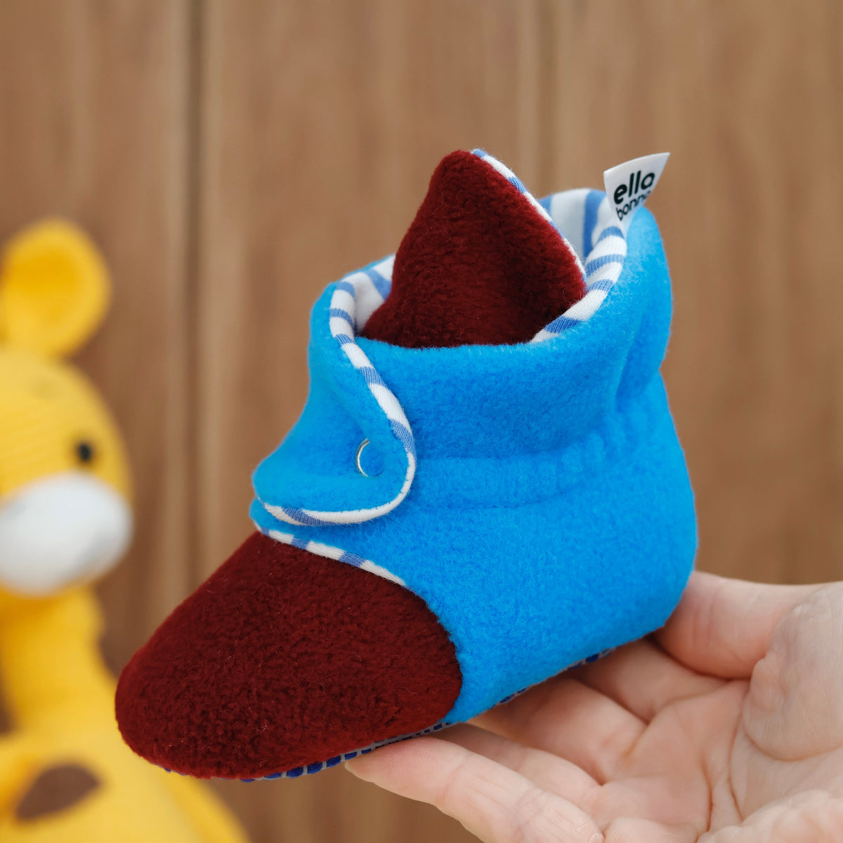 Single bootie held in a hand, side view.