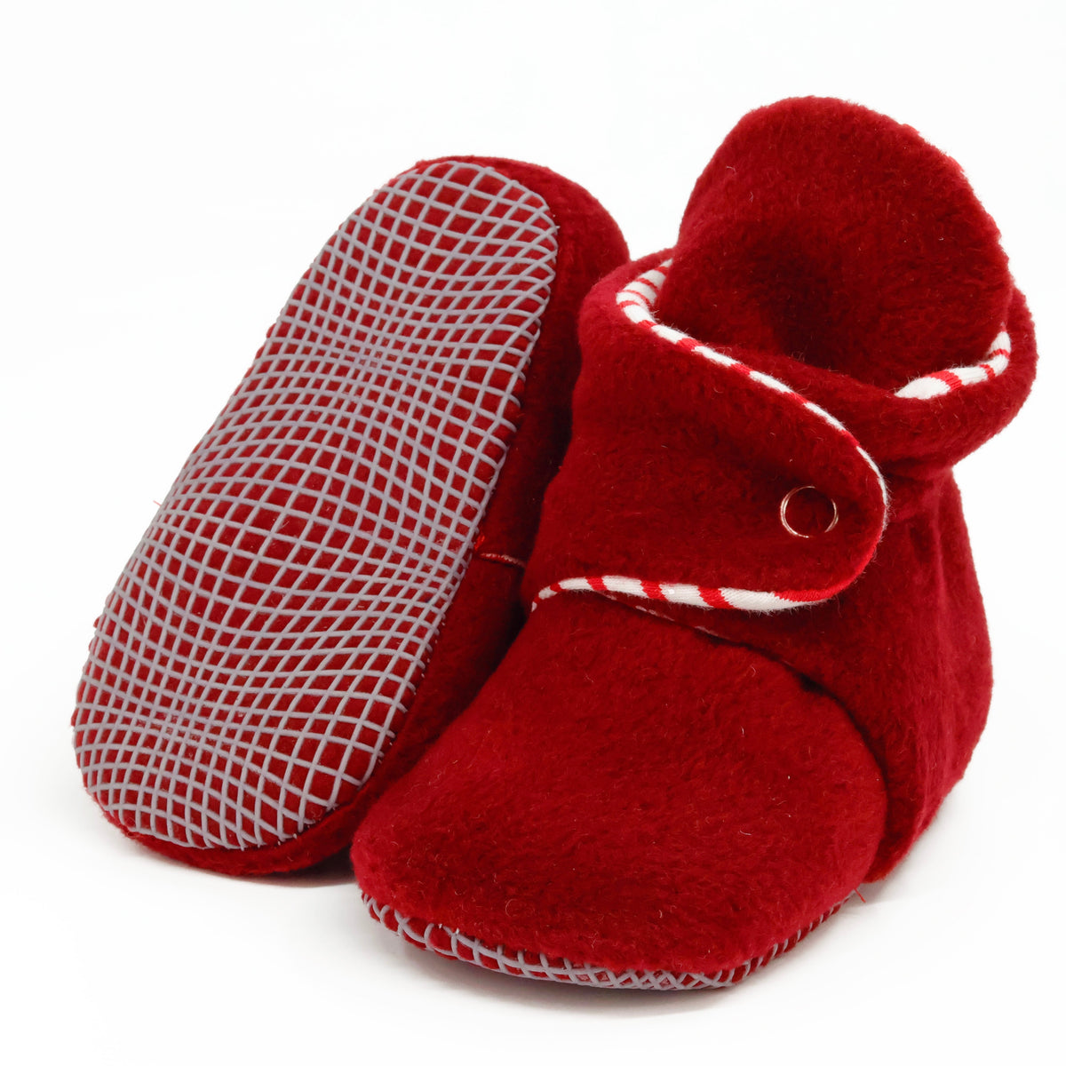 Burgundy fleece baby booties with striped lining and snap straps, with one sole facing the camera on a white background.