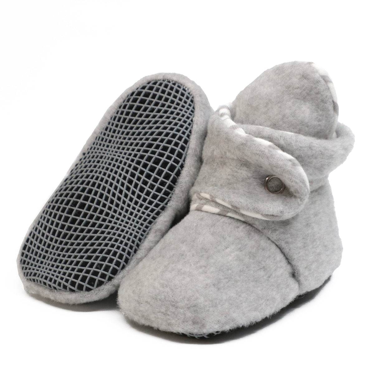 Light gray fleece baby booties with snap straps, with one sole facing the camera on a white background.