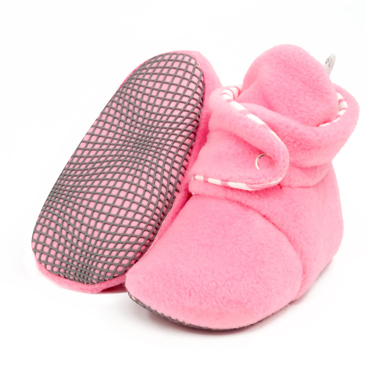 Pink fleece baby booties with striped lining and snap straps, with one sole facing the camera on a white background.