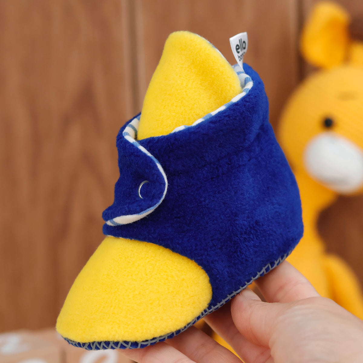 Single bootie held in a hand, side view.
