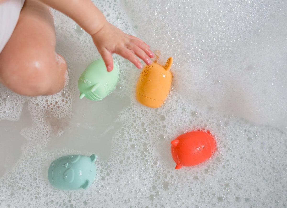 Lifestyle photo showing silicone bath toys with a child