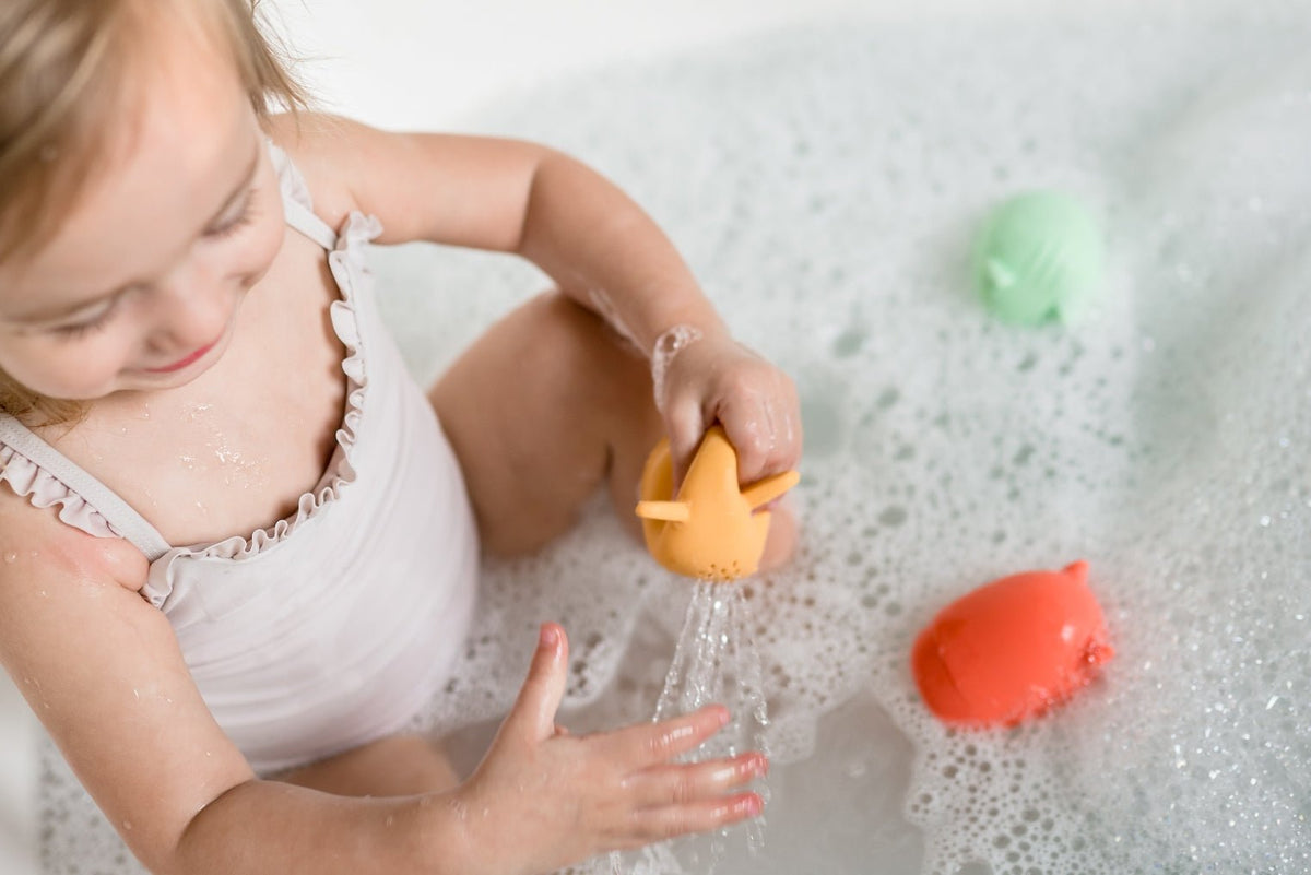 Lifestyle photo showing silicone bath toys with a child