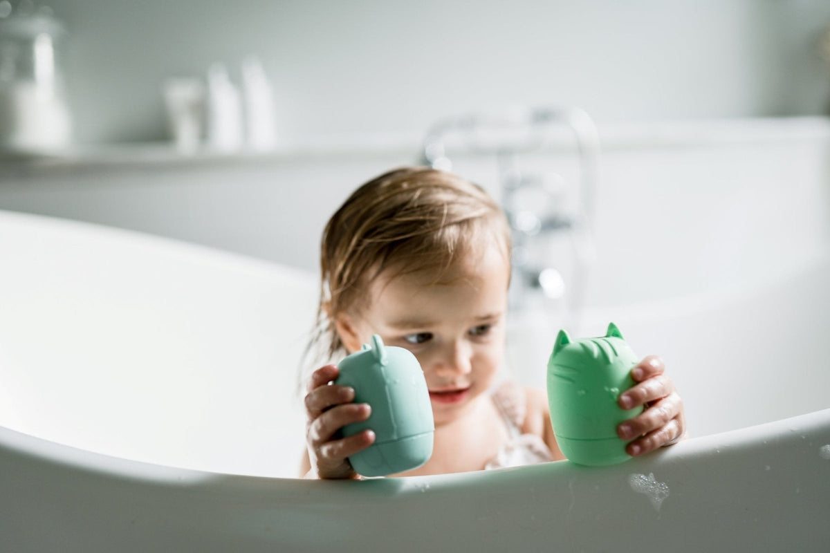 Lifestyle photo showing silicone bath toys with a child