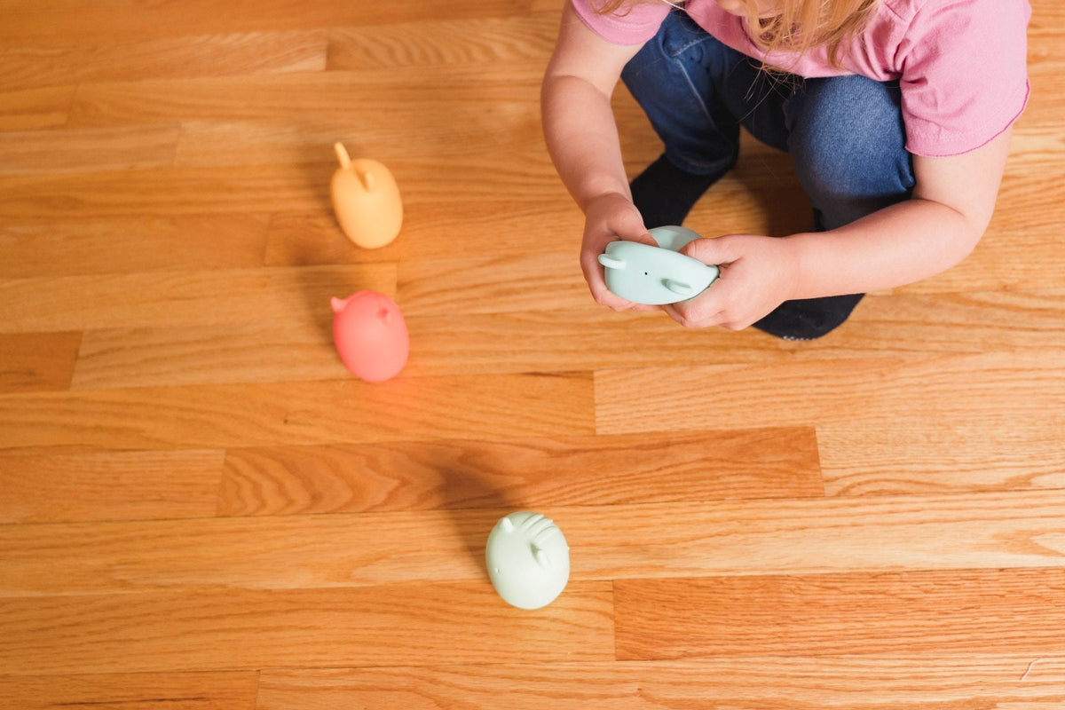 Lifestyle photo showing silicone bath toys with a child