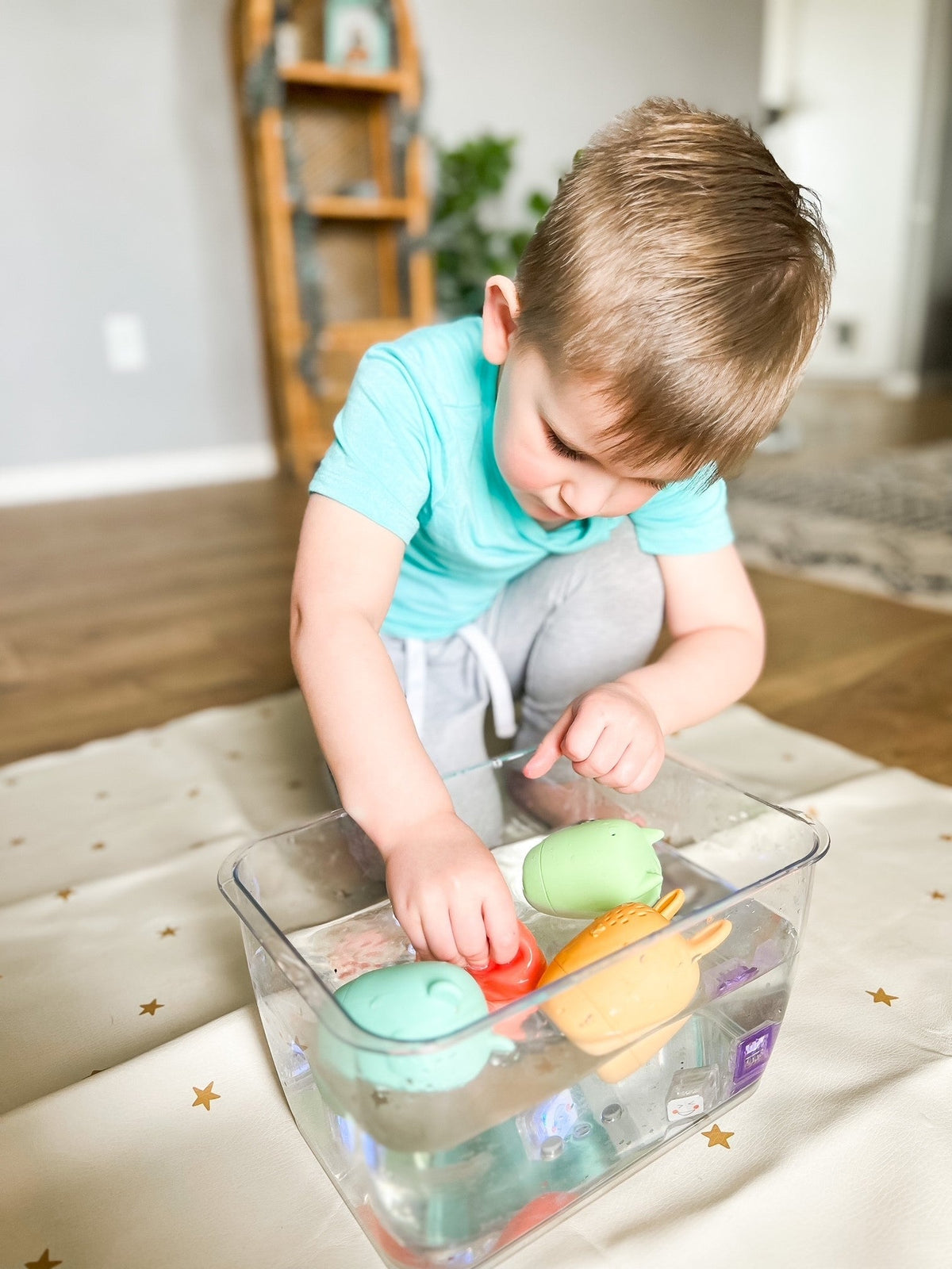 Lifestyle photo showing silicone bath toys with a child