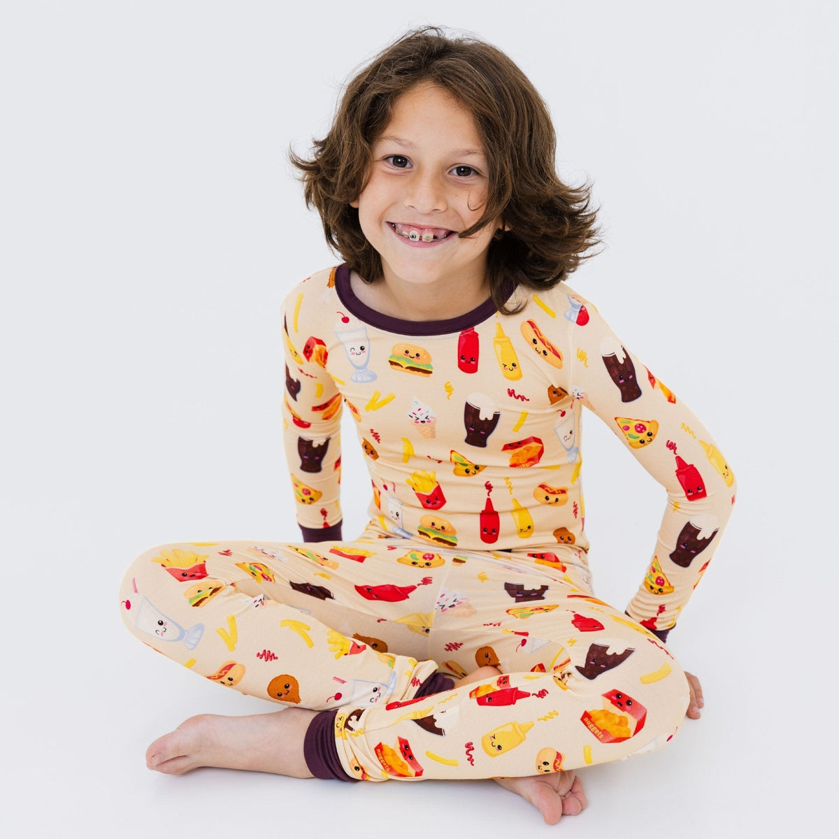 Child seated in Bam & Stitch Blissful Bites Long Sleeve Pajamas.