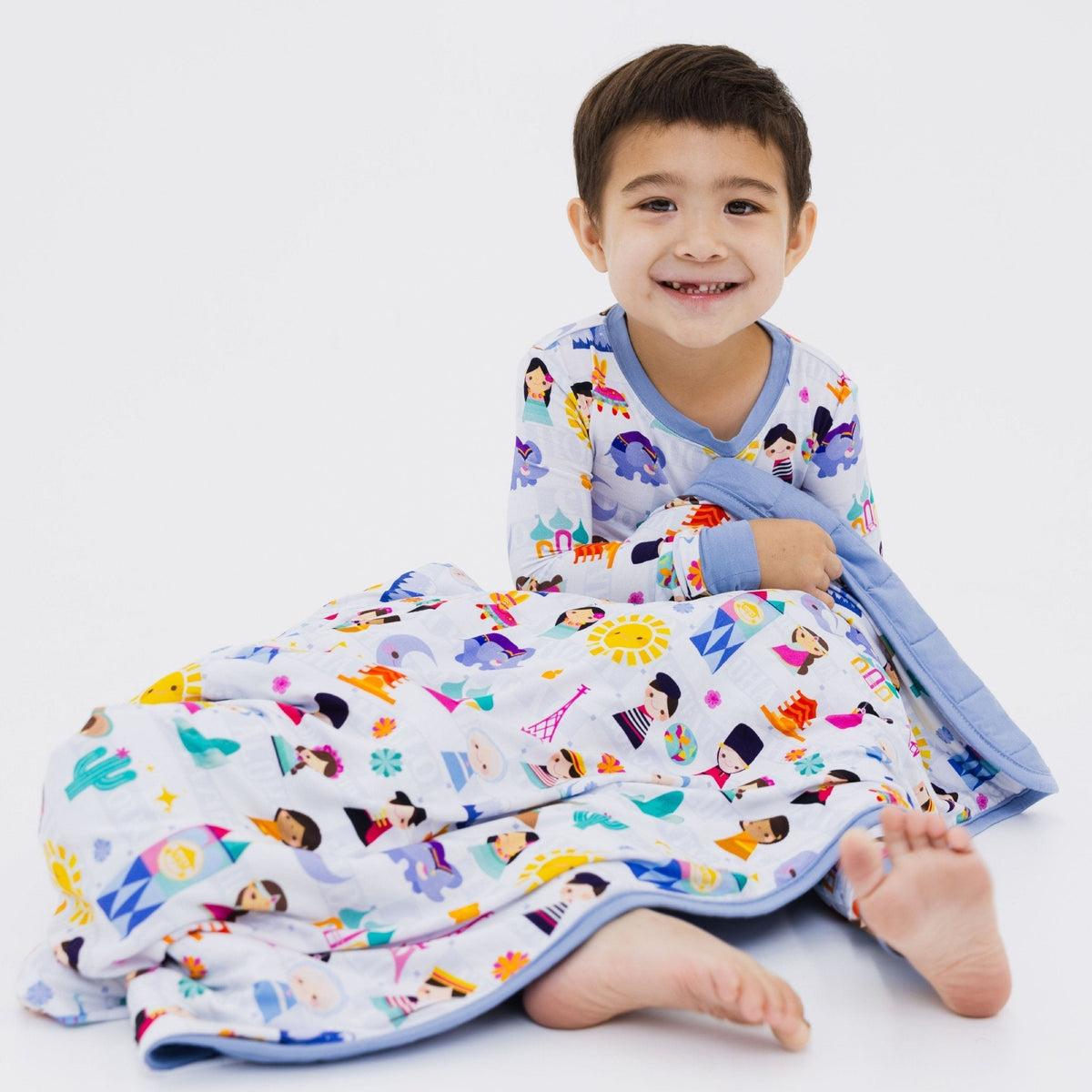 Child seated with Bam & Stitch Children of the World Blanket wrapped around them.
