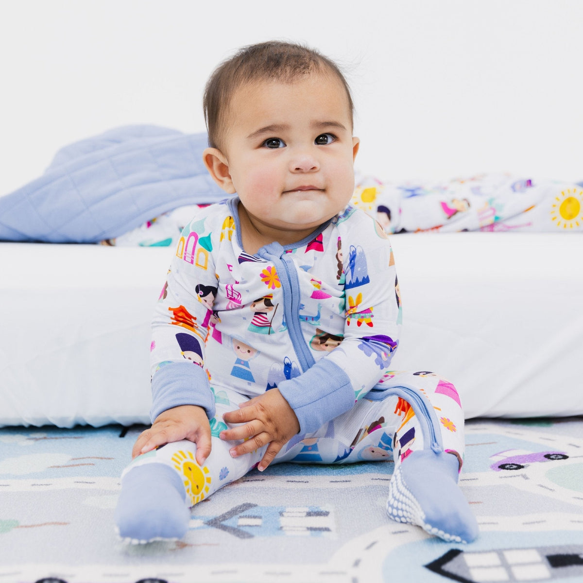 Baby sitting in Bam & Stitch Children of the World Convertible Romper.