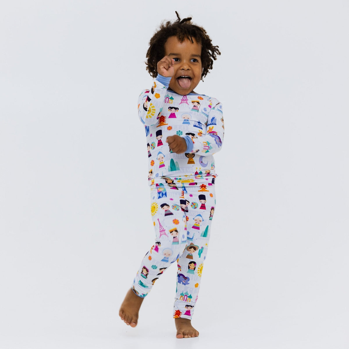 Child posing with one foot lifted in Bam & Stitch Children of the World Long Sleeve Pajamas.