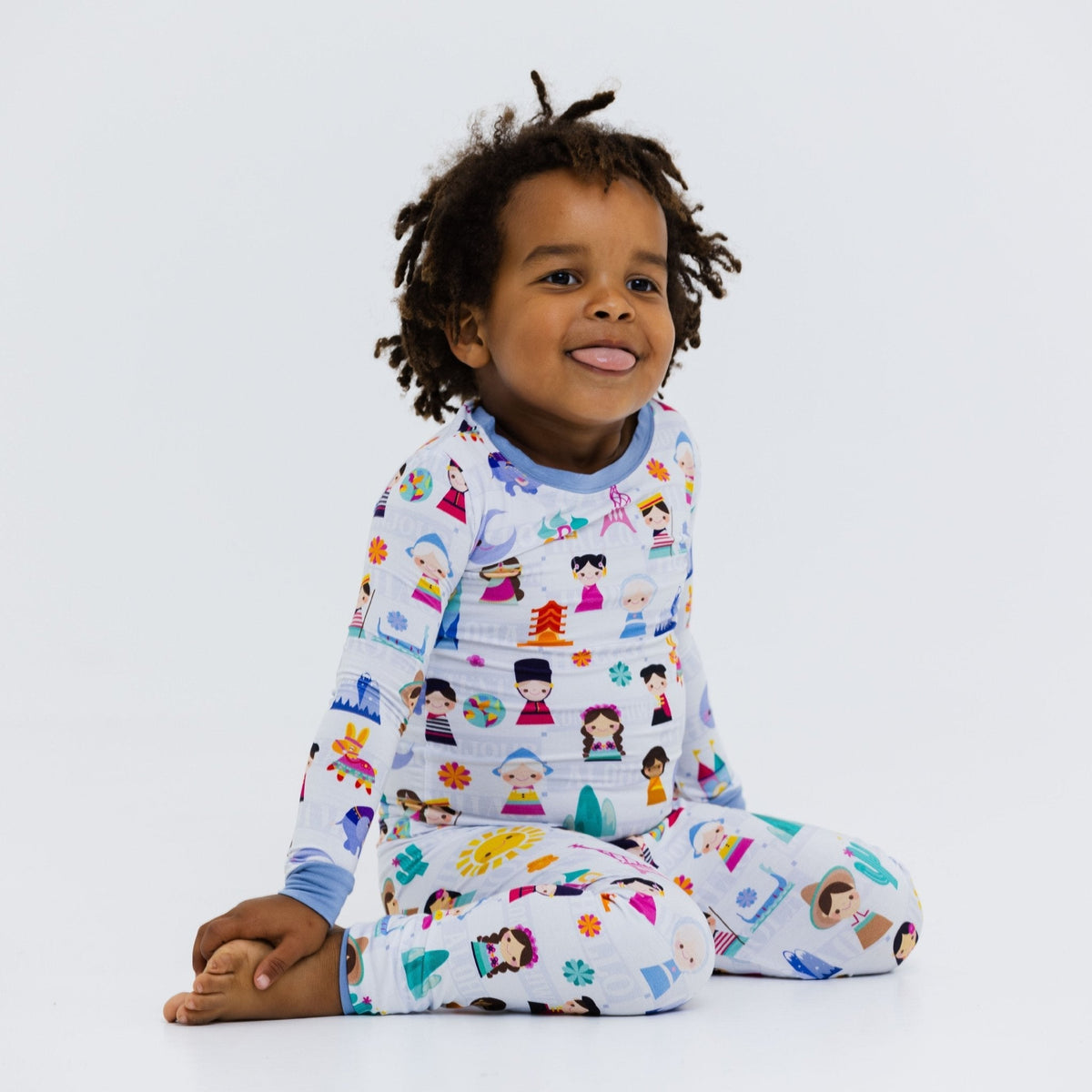 Child seated in Bam & Stitch Children of the World Long Sleeve Pajamas.