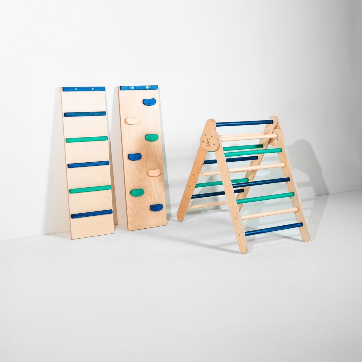 Classic Climber triangle with blue, teal and natural-tone rungs beside two upright ramps.