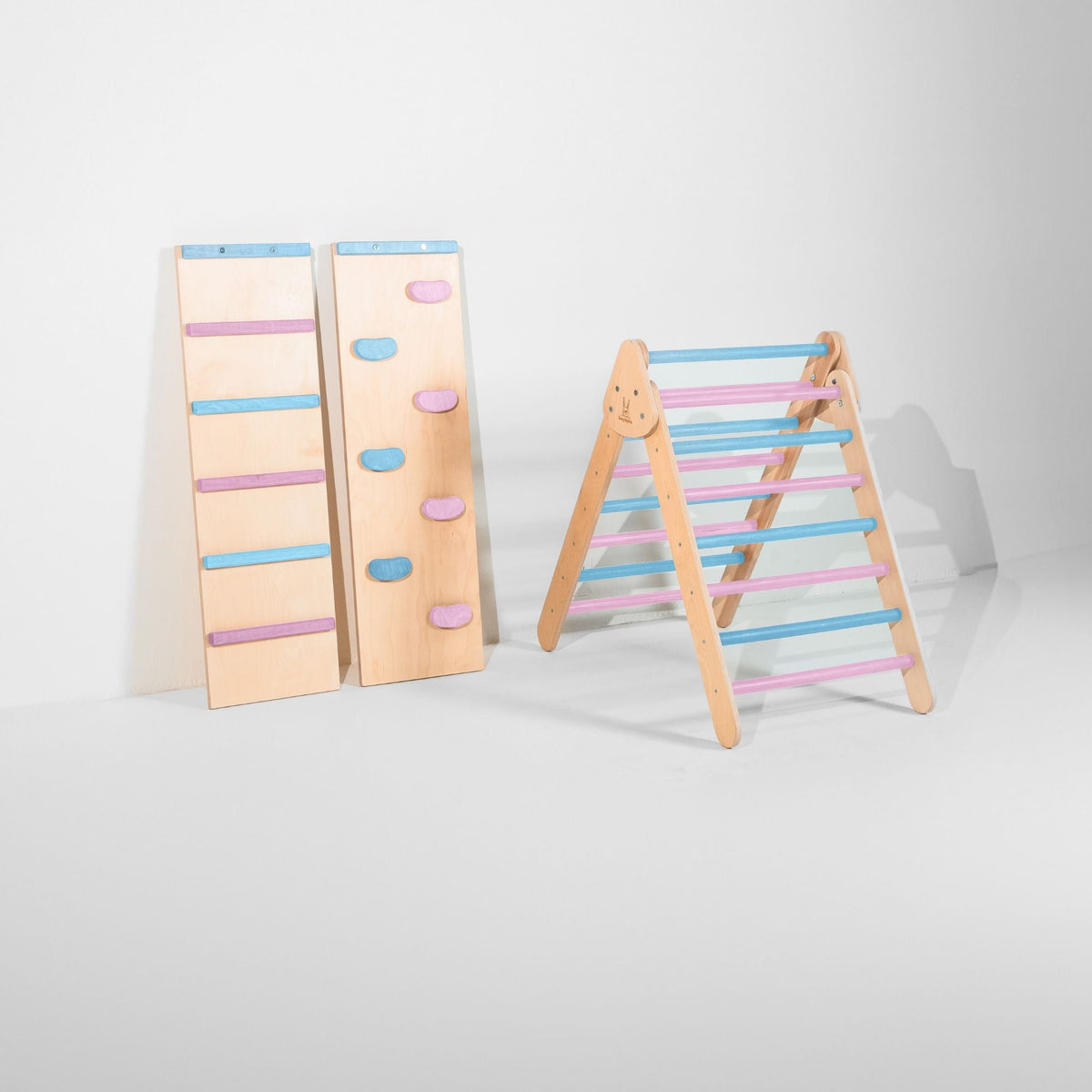 Classic Climber triangle with pastel blue and pink rungs beside two upright ramps.