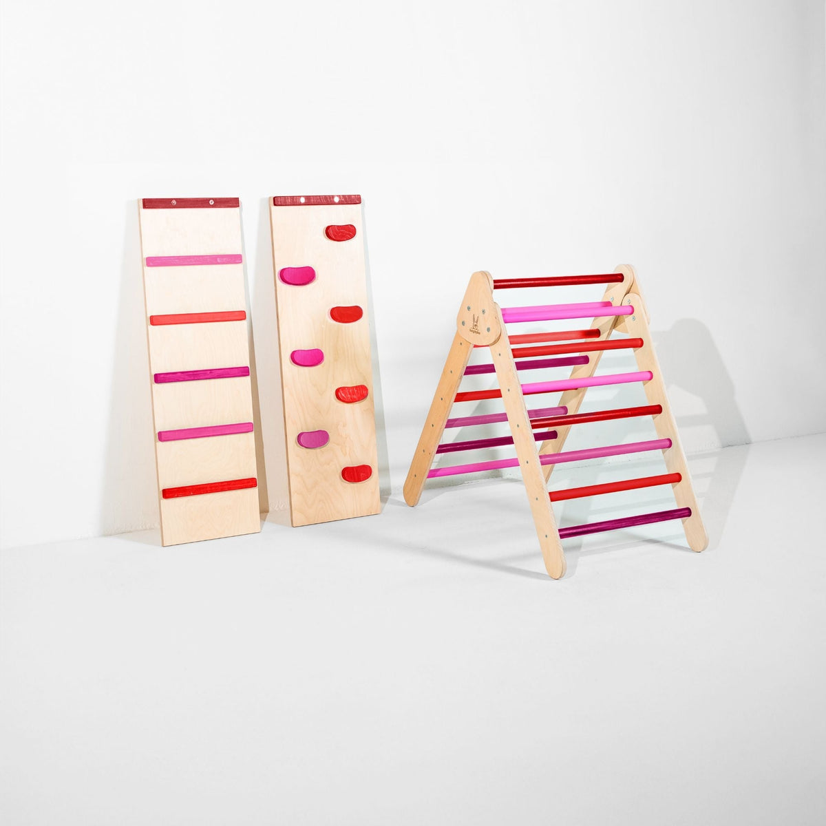 Classic Climber triangle with red and pink rungs beside upright ladder and climbing-hold ramps.