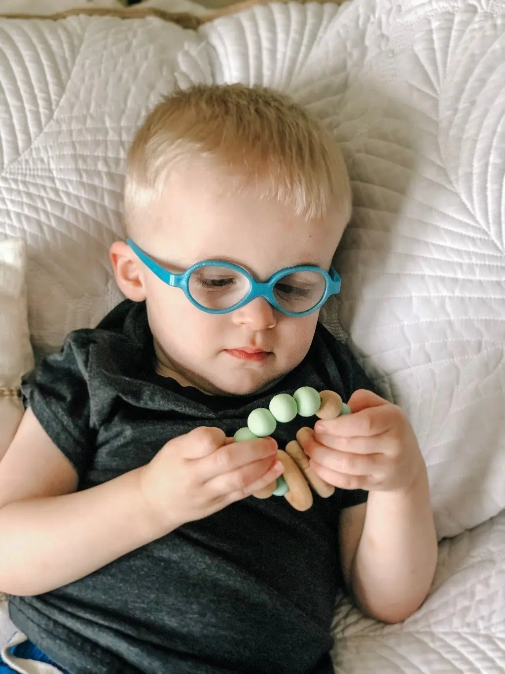 Lifestyle photo showing a wood and silicone teether with a child